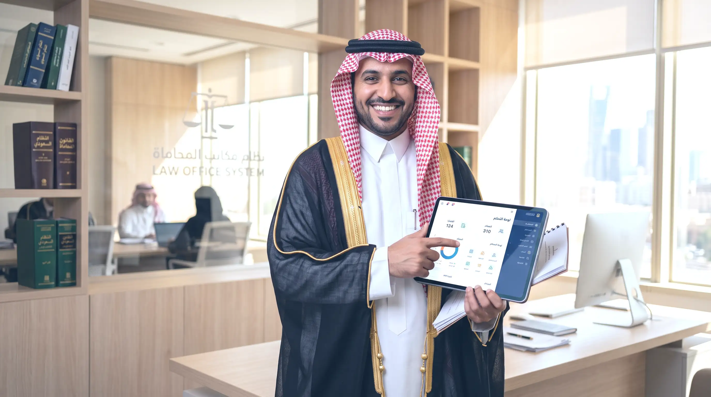 محامٍ سعودي يستعرض لوحة تحكم قضية على جهاز لوحي داخل مكتبه